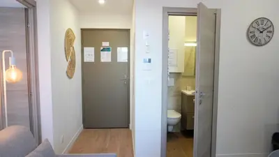 a bathroom with a toilet and a clock on the wall at Proche Carlton & Croisette, Appartement 101 - Palmazur Vacances in Cannes