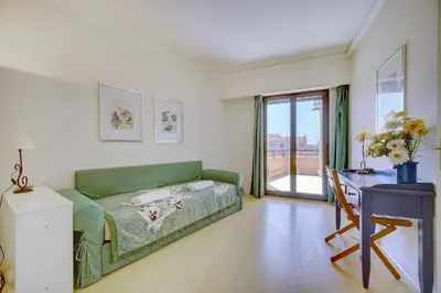 a living room with a green couch and a desk at 3 bedrooms in Cannes Center and south terrace in Cannes