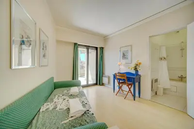 a bedroom with a green couch and a bathroom at 3 bedrooms in Cannes Center and south terrace in Cannes