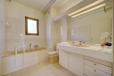 a white bathroom with a sink and a toilet and a tub at 3 bedrooms in Cannes Center and south terrace in Cannes