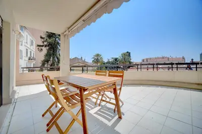 a wooden table and chairs on a balcony at 3 bedrooms in Cannes Center and south terrace in Cannes