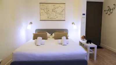 a bedroom with a white bed with a map on the wall at Proche Carlton & Croisette, Appartement 103 in Cannes