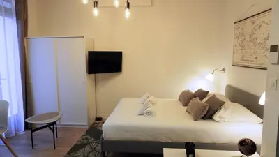 a bedroom with a bed and a tv on the wall at Proche Carlton & Croisette, Appartement 103 in Cannes