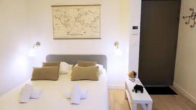 a bedroom with a white bed and a map on the wall at Proche Carlton & Croisette, Appartement 103 in Cannes