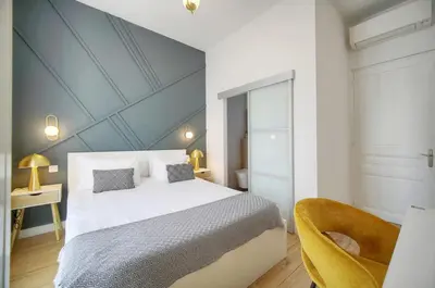 a bedroom with a large white bed and a chair at Deja Blue - Beautiful 4 beds & 4 baths, 10min from Palais, 4 stars residence in Cannes