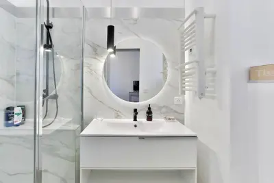 a white bathroom with a sink and a mirror at Deja Blue - Beautiful 4 beds & 4 baths, 10min from Palais, 4 stars residence in Cannes