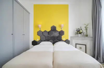 a bedroom with two white beds and a yellow wall at Deja Blue - Beautiful 4 beds & 4 baths, 10min from Palais, 4 stars residence in Cannes