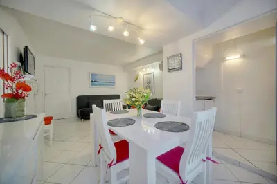 a kitchen and dining room with a white table and chairs at Confortable 2 pièces, HYPER CENTRE- CENTRE VILLE A1B237 in Cannes