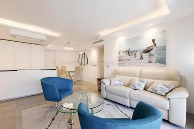 a living room with a white couch and blue chairs at Blue Bay in Cannes