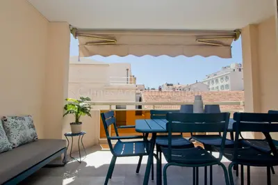 a balcony with a table and chairs and a couch at Blue Bay in Cannes