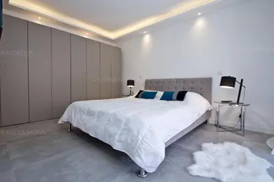 a white bedroom with a large white bed in it at Blue Bay in Cannes