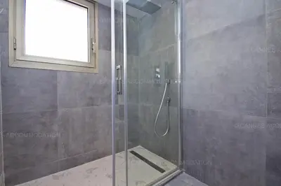 a shower with a glass door in a bathroom at Blue Bay in Cannes