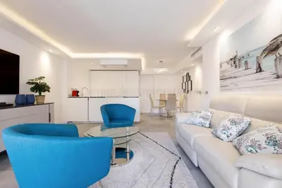 a living room with a white couch and blue chairs at Blue Bay in Cannes