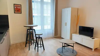 a living room with two bar stools and a television at Proche Carlton & Croisette, Appartement 203 - Palmazur Vacances in Cannes