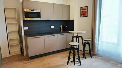 a kitchen with two bar stools and a counter top at Proche Carlton & Croisette, Appartement 203 - Palmazur Vacances in Cannes