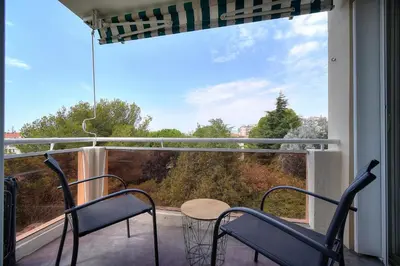 a balcony with chairs and a table and a large window at IMMOGROOM - Fully equipped - Terrace with sea view - AC in Cannes