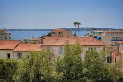 a group of buildings with trees and the water at IMMOGROOM - Fully equipped - Terrace with sea view - AC in Cannes