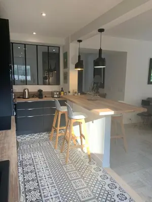 a kitchen with a wooden counter and stools in it at Appart Le Cannet in Le Cannet