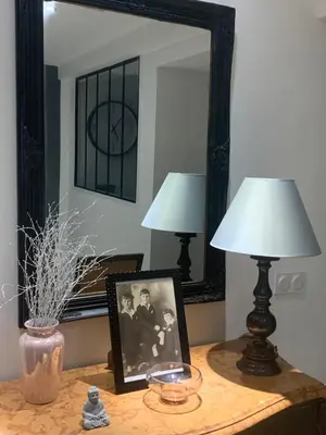 a table with two lamps and a picture and a mirror at Appart Le Cannet in Le Cannet