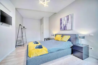 a bedroom with a bed with a yellow blanket at CROISETTE 8/10 pers in Cannes