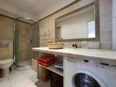 a bathroom with a washing machine and a mirror at Suquet 22 – 2 Pièces, Cannes Cœur Historique, Calme, Plage à 300m, Parking in Cannes