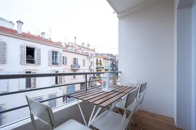 a balcony with a wooden table and chairs at Tredici- Appartment in Cannes