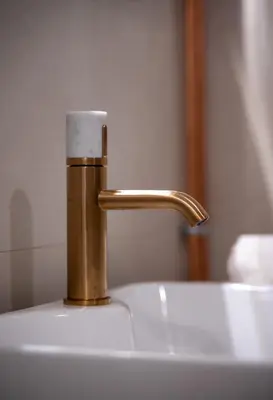 a sink with a gold faucet on top of it at Tredici- Appartment in Cannes