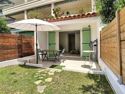 a patio with an umbrella and a table and chairs at Beautiful 1 bedroom with garden on the Croisette 254 in Cannes