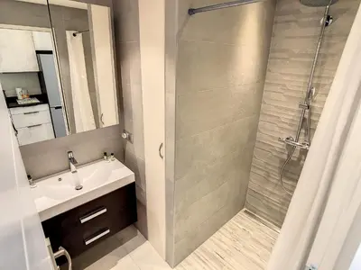 a kitchen with white cabinets and a refrigerator at Beautiful 1 bedroom with garden on the Croisette 254 in Cannes