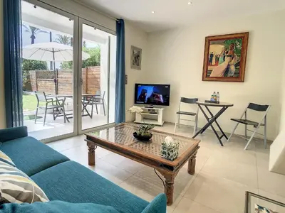 a living room with a blue couch and a table at Beautiful 1 bedroom with garden on the Croisette 254 in Cannes