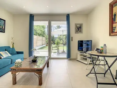 a living room with a blue couch and a table at Beautiful 1 bedroom with garden on the Croisette 254 in Cannes