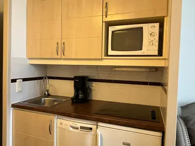 a kitchen with a sink and a microwave at Superbe appartement une chambre vue mer piscine tennis in Cannes