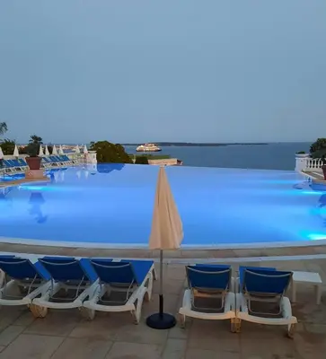 a row of chairs and a pool with blue water at Superbe appartement une chambre vue mer piscine tennis in Cannes