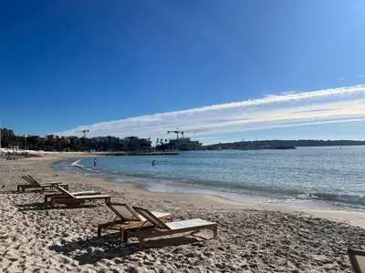 a beach with chaise lounges and the ocean at Superbe appartement une chambre vue mer piscine tennis in Cannes