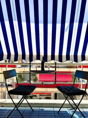 two chairs sitting under a blue and white umbrella at Lovely studio in the heart of Cannes in Cannes