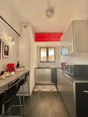 a kitchen with red cabinets and a counter top at Lovely studio in the heart of Cannes in Cannes