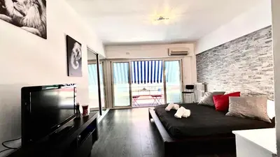 a living room with a couch and a brick wall at Lovely studio in the heart of Cannes in Cannes