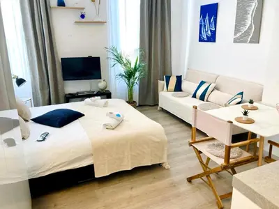 a bedroom with a large bed and a living room at Cannes: superbe studio x3 personnes, top position! in Cannes