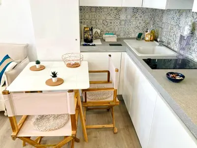 a small kitchen with white cabinets and a small table at Cannes: superbe studio x3 personnes, top position! in Cannes