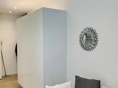 a white cabinet in a living room with a mirror at Cannes: superbe studio x3 personnes, top position! in Cannes