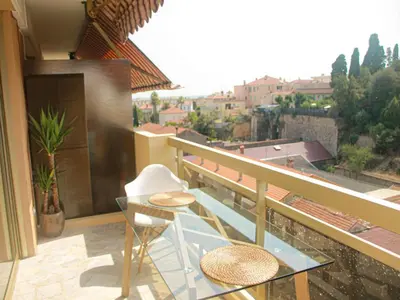 a balcony with a glass table and chairs on a balcony at Cozy studio apartment in Cannes - AC-Self check-in in Cannes