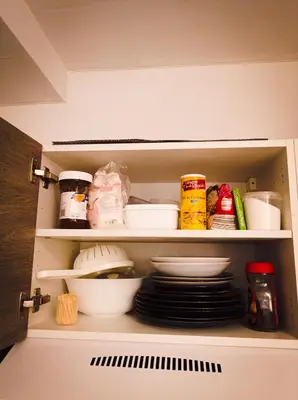 a cupboard with plates and other food items in it at L'étoile pétillante in Cannes