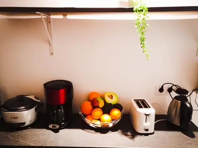 a bowl of fruit on a counter next to a coffee maker at L'étoile pétillante in Cannes