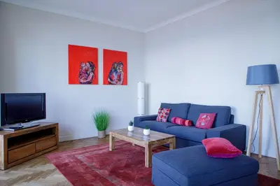 a living room with a blue couch and a tv at Bel Appartement Face à La Mer Près Du Centre - Le Voilier by Halldis in Cannes