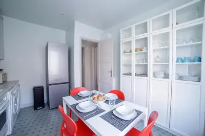 a kitchen with a white table and red chairs at Bel Appartement Face à La Mer Près Du Centre - Le Voilier by Halldis in Cannes