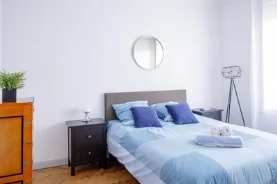 a bedroom with a bed with blue pillows and a mirror at Bel Appartement Face à La Mer Près Du Centre - Le Voilier by Halldis in Cannes