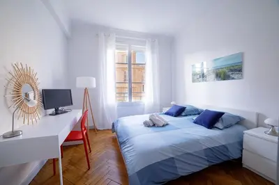 a bedroom with a bed and a desk with a computer at Bel Appartement Face à La Mer Près Du Centre - Le Voilier by Halldis in Cannes