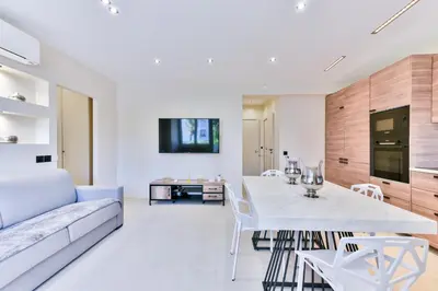 a living room with a table and a couch at Cosy flat with parking - Basse Californie - Cannes in Cannes