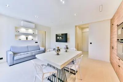 a living room with a table and chairs and a couch at Cosy flat with parking - Basse Californie - Cannes in Cannes