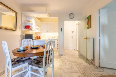 a kitchen and dining room with a table and chairs at LB Vacation Rentals I Cannes Croisette, Large Terrace, Free Parking, Beaches in Cannes